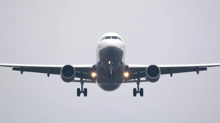 Avion de ligne en approche frontale sur fond gris