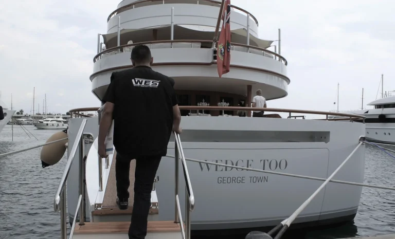 Employé WES montant à bord d’un yacht amarré